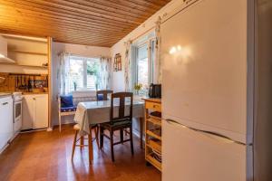 a kitchen with a table and a refrigerator at KRO891-Hallaryd-Kalvshult-8 in Hallaryd +8 photos