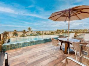 a patio with a table and chairs and a pool at Cabo Branco - Fortune in Tambaú