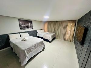 a hotel room with two beds and a television at Cabo Branco - Fortune in Tambaú +23 photos