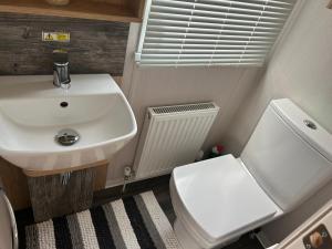 a small bathroom with a sink and a toilet at Dollys Den in Pagham +18 photos