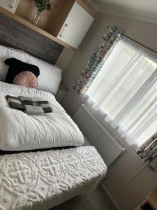 a small bedroom with a bed and a window at Dollys Den in Pagham