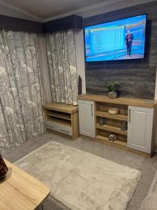 a living room with a large flat screen tv at Dollys Den in Pagham