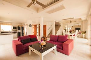 a living room with two red chairs and a table at Smile House Villa in Thong Son Beach