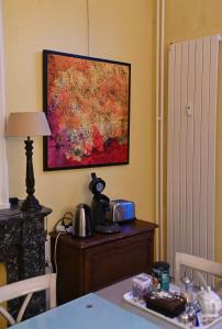 a painting hanging on a wall next to a table at Le Chateau Blanc in Verviers