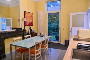 a kitchen and dining room with a glass table and chairs at Le Chateau Blanc in Verviers