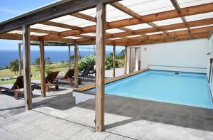a swimming pool under a wooden pergola at Quinta da Meia Eira in Horta