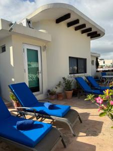 a row of blue lounge chairs on a patio at Casa Delfin in Playa del Carmen