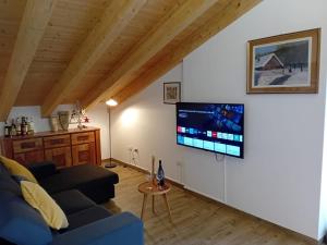 a living room with a couch and a flat screen tv at Casa Moreschi in Tresivio