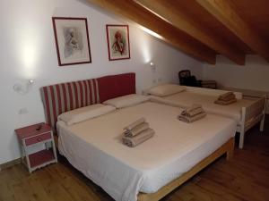 a bedroom with two beds with towels on the bed at Casa Moreschi in Tresivio