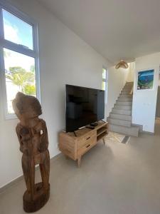 a living room with a television and a bear statue at White Sand Villa - infinity pool in Paea