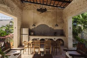 a patio with a table and chairs and a fireplace at Campeche Mágico in Campeche
