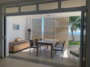 a dining room with a table and chairs and a bedroom at White Sand Villa - infinity pool in Paea