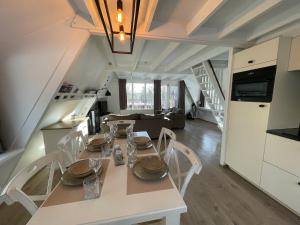 a kitchen and living room with a table and chairs at ArdennenVakantieBungalow in Durbuy