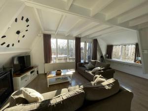 a living room with two couches and a tv at ArdennenVakantieBungalow in Durbuy