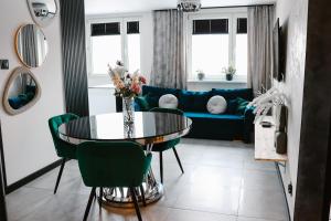 a living room with a blue couch and a table at Apartament Patka Wysoki STANDARD in Grudziądz
