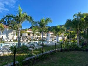 a resort with a swimming pool and palm trees at White Sand Villa - infinity pool in Paea