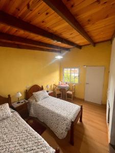 a bedroom with two beds and a dining room with a table at Max in El Chalten