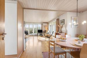 a dining room and living room with a table and chairs at LL261-Humble-Gyvelvaenget-1 in Spodsbjerg