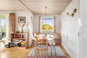 a dining room with a table and chairs at LL261-Humble-Gyvelvaenget-1 in Spodsbjerg +11 photos