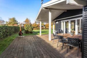 a wooden deck with a table and a rooster on it at LL261-Humble-Gyvelvaenget-1 in Spodsbjerg