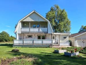 a large white house with a porch and a yard at VGO959-Kalv-Gunnarpsvaegen-3 in Kalv