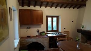 a kitchen with a brick fireplace and a table and a window at Il Merangolo in Montebuono
