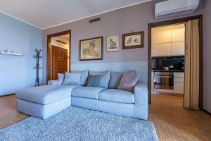 a living room with a blue couch and a kitchen at Ca Maria Peonie Apartment in Bellagio