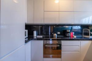 a kitchen with white cabinets and a sink at Ca Maria Peonie Apartment in Bellagio +6 photos