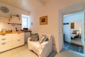 a living room with a white couch and a kitchen at Loving Loppia - Glicine in Bellagio