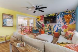 a living room with a couch and a ceiling fan at The Tropical Cottage in Long Beach
