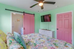 a bedroom with a bed and a pink door at The Tropical Cottage in Long Beach