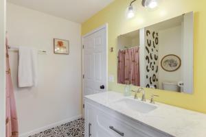 a bathroom with a sink and a mirror at The Tropical Cottage in Long Beach +15 photos