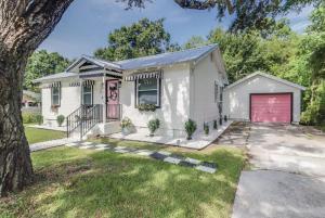 a white house with a red garage at The Tropical Cottage in Long Beach