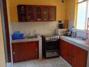 a kitchen with a stove and a sink at Apartamentos en Huanchaco in Huanchaco +18 photos