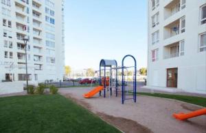 a playground in a park next to a building at Arena Marina-Sol l in El Cerrillo