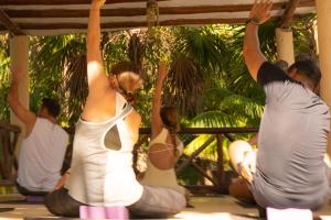 a group of people doing a yoga pose at Zomay Beachfront Holbox in Holbox Island