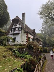 a woman walking past a house on a hill at House Vila Santa Ana in Santana