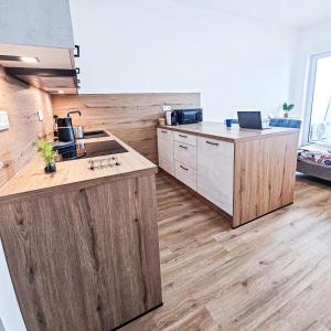 a large kitchen with wooden counters and a counter top at B-point apartments in Komárov +8 photos