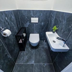 a bathroom with a white toilet and a sink at B-point apartments in Komárov