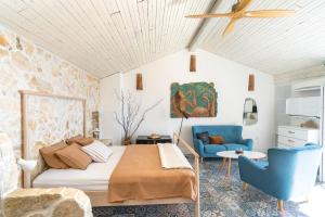a bedroom with a bed and a blue chair at Libera Apartments in Stara Baška