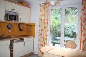 コゴランにあるFerienhaus bei St. Tropezの窓、テーブル付きのキッチンが備わります。