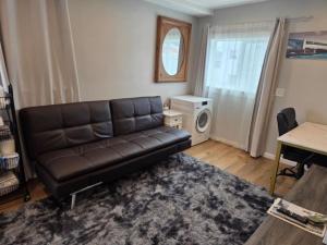 a living room with a leather couch and a table at Modern Victorian by Beach and Forest Unit B in Crescent City