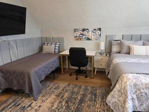 a room with two beds and a desk with a computer at Modern Victorian by Beach and Forest Unit C in Crescent City