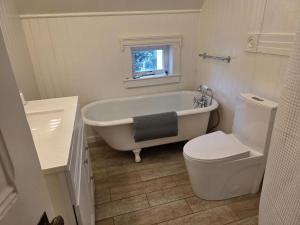 a bathroom with a tub and a toilet and a sink at Modern Victorian by Beach and Forest Unit C in Crescent City