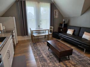 a living room with a black leather couch and a table at Modern Victorian by Beach and Forest Unit C in Crescent City