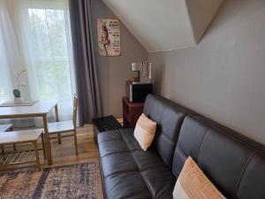 a living room with a leather couch and a table at Modern Victorian by Beach and Forest Unit C in Crescent City