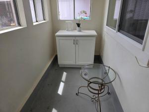a table and a chair in a room with windows at Modern Victorian by Beach and Forest Unit D in Crescent City