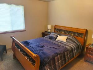 a bedroom with a bed with a wooden frame and a window at The Hofer Beach Retreat in Crescent City