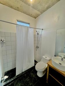 a bathroom with a toilet and a sink at Hostal Luz Del Valle in Santa Bárbara de Samaná