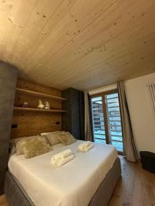 a bedroom with a large bed with a wooden ceiling at Maison ValGià in Champoluc